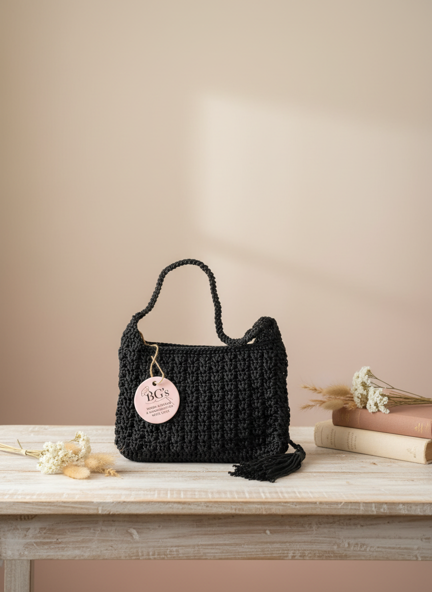 Black woven handbag with a pink tag on a wooden surface against a beige wall