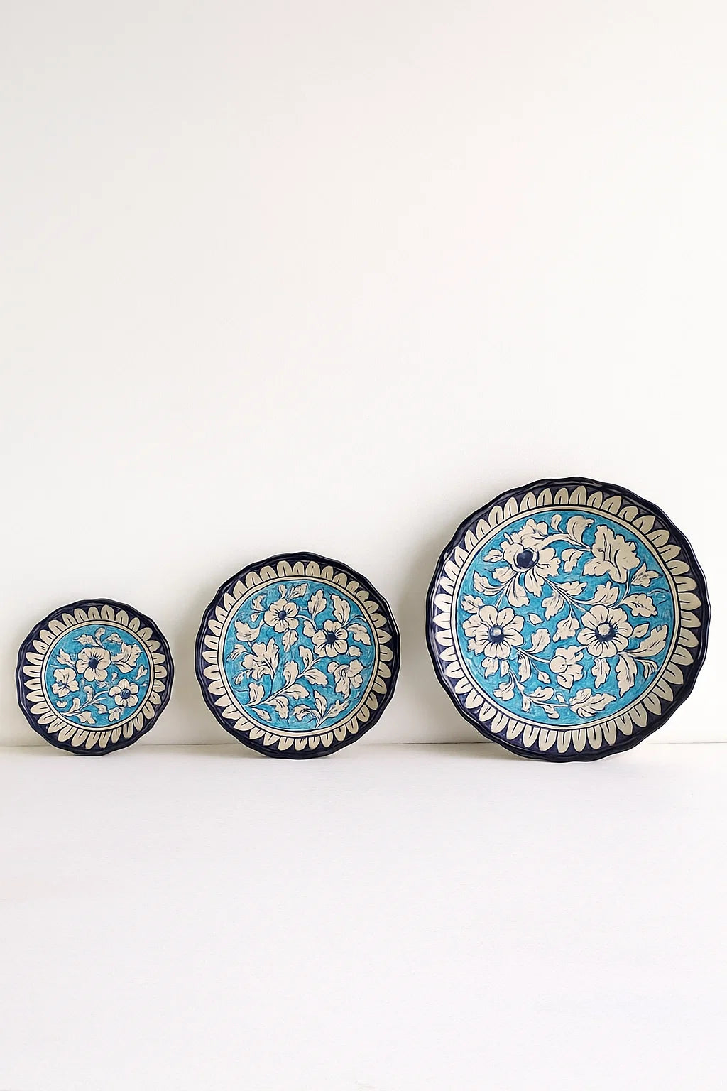 Three decorative plates with floral patterns on a white background