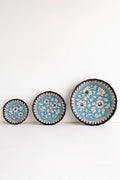 Three decorative plates with floral patterns on a white background