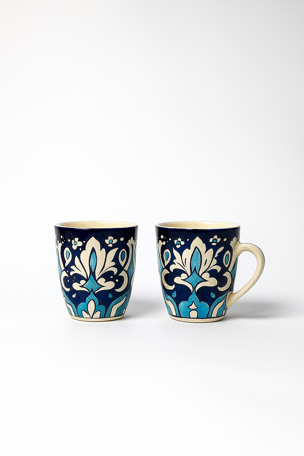 Two ceramic mugs with decorative blue patterns on a white background