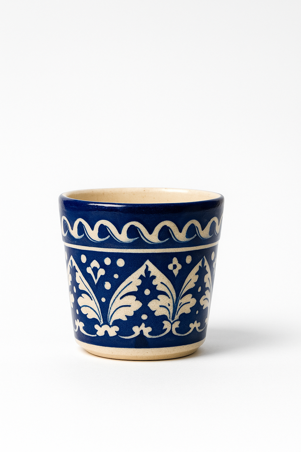Blue ceramic cup with white decorative patterns on a white background