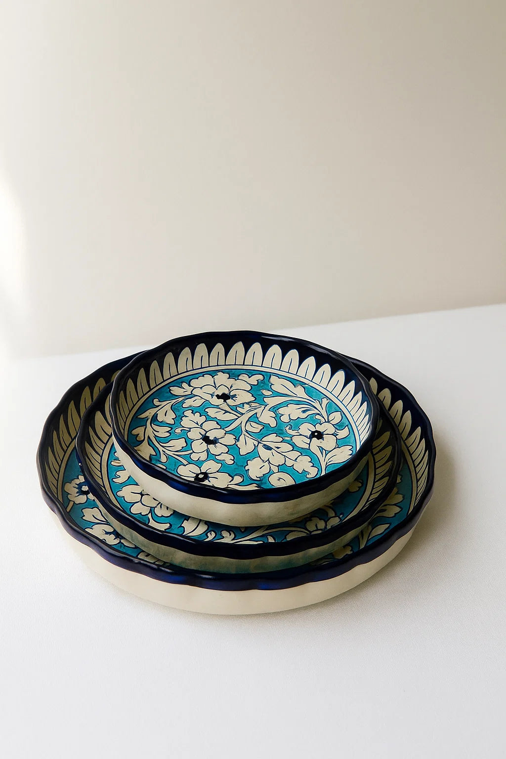 Set of three ceramic bowls with blue and white floral patterns on a white surface.