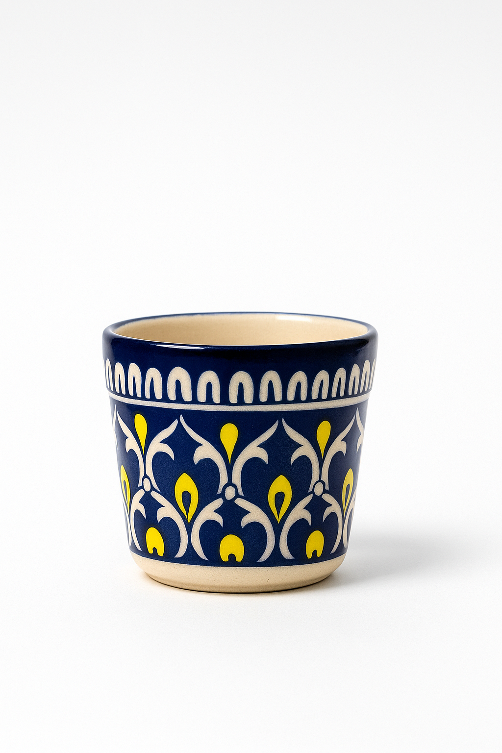 Ceramic cup with decorative blue and yellow pattern on a white background